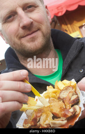 Neuwied, Germania. 27 gennaio, 2017. Michael è mangiare una salsiccia al curry con patatine fritte al festival della salsiccia al curry in Neuwied, Germania. 35 i provider sono presentando le loro variazioni del piatto in corrispondenza di numerosi stand. Michael isst am 27.01.2017 in Neuwied (Renania-Palatinato) beim Festival der Currywurst eine Currywurst mit pommes frites. 35 Anbieter präsentieren un ihren Ständen ihre Variationen des Gerichts. Credito: Thomas Frey/dpa/Alamy Live News Foto Stock