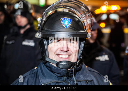 New York, Stati Uniti d'America. Il 28 gennaio 2017. Gli ufficiali di polizia guardare la folla di manifestanti la dimostrazione contro il presidente statunitense Trump's divieto di immigrazione a New York John F Kennedy International Airport Credito: Konstantin Sergeyev/Alamy Live News Foto Stock