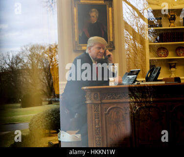 Washington, Stati Uniti d'America. Il 29 gennaio, 2017. Il presidente statunitense Donald Trump parla al telefono con il re di Arabia Saudita, Salman bin Abd al-Aziz Al Saud nell'Ufficio Ovale della Casa Bianca. Credito: Aude Guerrucci/Piscina via CNP/MediaPunch/Alamy Live News Foto Stock