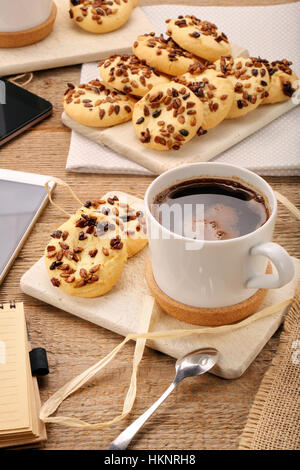 Tazza di caffè tazza con croccante di cookie sul tavolo e white smart phone con spazio vuoto per il testo Foto Stock