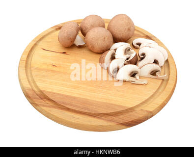 Affettato e fresco intero funghi castagne con copia spazio su un tagliere di legno, isolato su sfondo bianco Foto Stock