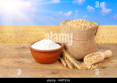 Chicchi di grano e farina su sfondo natura Foto Stock