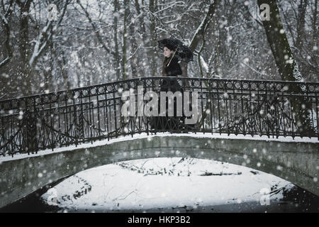 La donna in nero abito vittoriano nel Winter Park Foto Stock