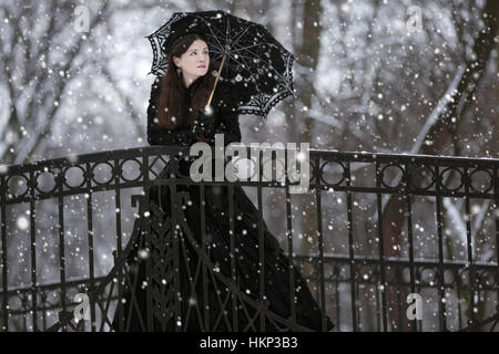 La donna in nero abito vittoriano nel Winter Park Foto Stock