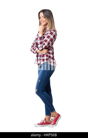 Splendida street style donna che indossa jeans, plaid shirt e sneakers sorridente. Corpo pieno lunghezza ritratto isolato su bianco Foto Stock