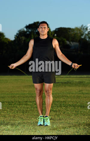 Sportman Uomo salto con la corda sul prato verde park Foto Stock