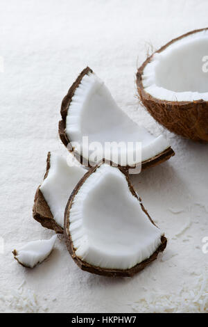 Materie tutta crepata di noce di cocco aperta su uno sfondo bianco Foto Stock