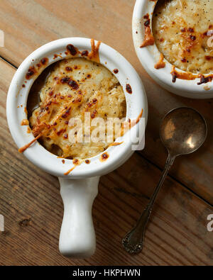 Due ciotole di zuppa di cipolle francese su una tavola di legno Foto Stock
