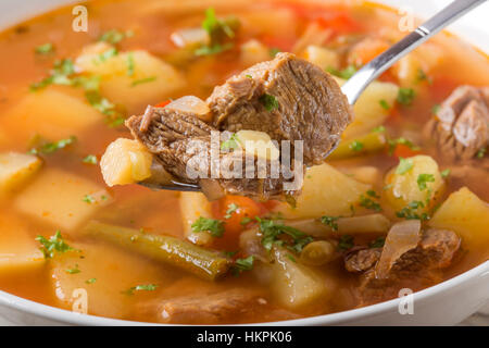 Chiusura del cucchiaio riempito con verdure zuppa di carne di manzo Foto Stock