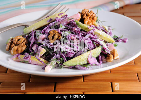 Insalata coleslaw rosso con fette di avocado, Apple, dadi, prezzemolo, aneto condito salsa di yogurt Foto Stock