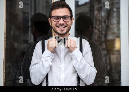 Lo sposo in camicia bianca sorridendo vicino alla finestra Foto Stock