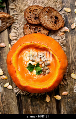 Zuppa di zucca, semi e pane tostato, vista dall'alto Foto Stock