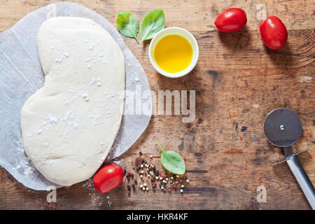 Impasto per pizza e i componenti per la preparazione a caldo in casa rurale salute pizza. Ingredienti alimentari sullo sfondo di legno. piccola mozzarella, funghi, g Foto Stock