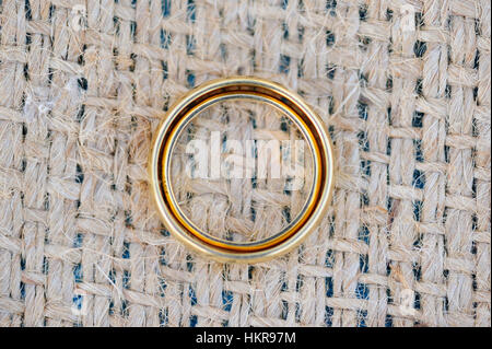 Anelli d oro che stabilisce insieme sulla tavola con lino Foto Stock