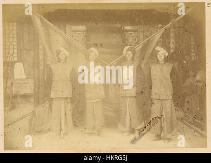 Questa foto storica del 1875 mostra i soldati cinesi dello Xinjiang in distintive uniformi militari. I soldati sono vestiti con giacche di lana, pantaloni in velluto e turbanti, riflettendo lo stile culturale e militare unico della regione durante la tarda dinastia Qing. Foto Stock