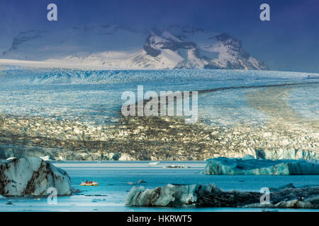 Una barca a Jokulsarlon lago glaciale, Vatnajokull National Park nel sud-est dell'Islanda - iceberg e il ghiacciaio Vatnajokull Foto Stock