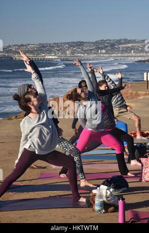 San Diego, Stati Uniti d'America. Il 27 gennaio, 2017. La pratica dello yoga al San Diego Festival di Yoga sulla spiaggia dell'oceano di San Diego, California. Questa classe è stata una delle molte lezioni di yoga, guidati da oltre 50 della California del sud gli insegnanti master, offerto nel corso dei tre giorni della manifestazione. Questa sessione di yoga è stato offerto su Sunset Cliffs al tramonto. Credito: John D. Ivanko/Alamy Live News Foto Stock