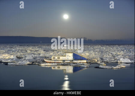 Belgrado, Serbia, gennaio 2017, chiaro di luna e la piccola barca a congelati fiume Danubio a Belgrado Foto Stock