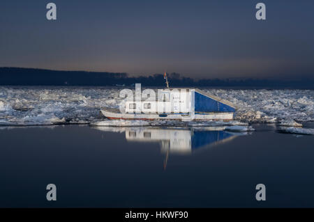 Belgrado, Serbia, gennaio 2017, piccola barca sul Danubio FROZEN RIVER di Belgrado nella notte Foto Stock