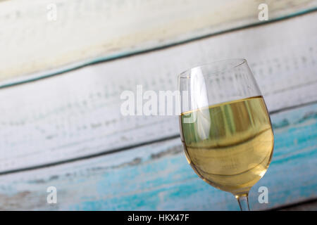 Bicchiere di vino bianco versata da una bottiglia Foto Stock