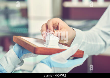 Ritagliare dei maschi di mano azienda golden ring in . Foto Stock