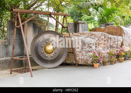 Gong tailandese a Phuket. La tradizione campana asiatici nel tempio buddista in Thailandia. Famosa campana grande desiderio vicino al Buddha d'Oro Foto Stock