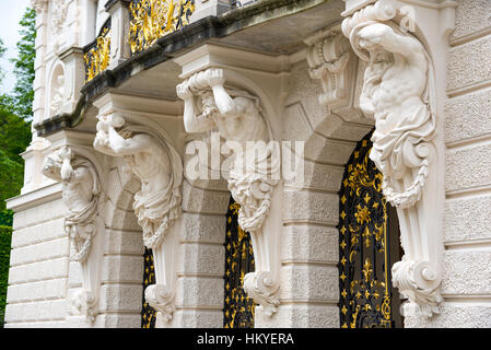 Un gruppo di uomini di scultura balcone di supporto dell'edificio principale del Linderhof Palace. La Baviera, Germania. Foto Stock