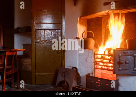Un fuoco ardente in un minatore della cottage. Foto Stock