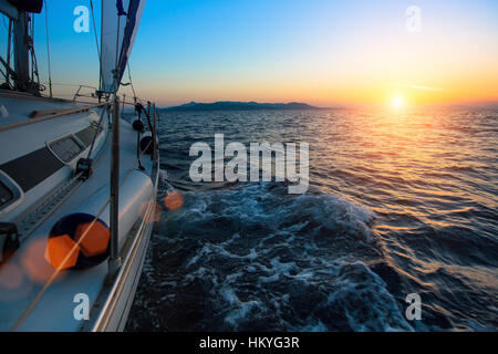 Racing su barche nel vento sulle onde del mare durante il tramonto da favola. Luxury Yacht a vela in regata. Foto Stock