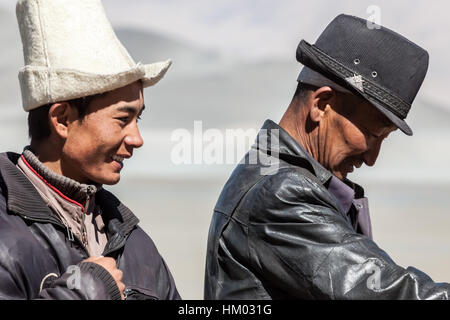 Uomo del Kirghizistan nei tradizionali hat pone in campagna montuosa dell altopiano del Pamir dalla Karakoram Highway, Xijiang, Cina. Foto Stock