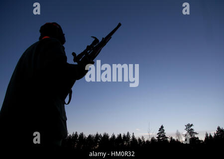 Hunter in piedi nel bosco di notte Foto Stock