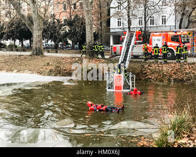 Stuttgart, Germania - 25 Gennaio 2017: il corpo dei vigili del fuoco di Stoccarda è condurre un esercizio di salvataggio di un uomo la rottura in un lago ghiacciato in inverno Foto Stock