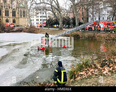 Stuttgart, Germania - 25 Gennaio 2017: il corpo dei vigili del fuoco di Stoccarda è condurre un esercizio di salvataggio di un uomo la rottura in un lago ghiacciato in inverno Foto Stock