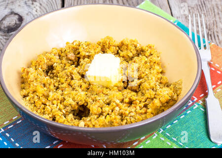 Lato piatto di lenticchie con verdure e burro in ciotola di legno su b Foto Stock