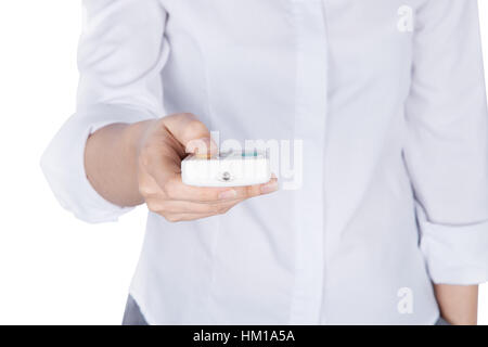 Mano trattiene un condizionatore d'aria di comando remoto con corpo isolato su sfondo bianco (con percorso di clipping) Foto Stock