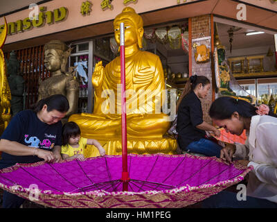 Bangkok, Tailandia. Il 1° febbraio 2017. Le donne fanno grandi ombrelloni tradizionali in un negozio che vende e fornisce paraphernalia buddista di Bangkok. Gli ombrelli sono utilizzati come ombrelloni per mantenere il sole spento importanti statue di Buddha e a eventi formali. Nella cultura tailandese, gli ombrelloni sono stati usati per fornire ombra per i membri della famiglia reale o i rappresentanti della famiglia reale. Credit: Jack Kurtz/ZUMA filo/Alamy Live News Foto Stock