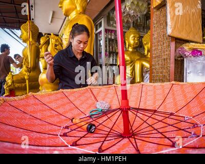 Bangkok, Tailandia. Il 1° febbraio 2017. Una donna che lavora su un grande ombrellone tradizionale in un negozio che vende e fornisce paraphernalia buddista di Bangkok. Gli ombrelli sono utilizzati come ombrelloni per mantenere il sole spento importanti statue di Buddha e a eventi formali. Nella cultura tailandese, gli ombrelloni sono stati usati per fornire ombra per i membri della famiglia reale o i rappresentanti della famiglia reale. Credit: Jack Kurtz/ZUMA filo/Alamy Live News Foto Stock