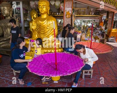 Bangkok, Tailandia. Il 1° febbraio 2017. Le donne fanno grandi ombrelloni tradizionali in un negozio che vende e fornisce paraphernalia buddista di Bangkok. Gli ombrelli sono utilizzati come ombrelloni per mantenere il sole spento importanti statue di Buddha e a eventi formali. Nella cultura tailandese, gli ombrelloni sono stati usati per fornire ombra per i membri della famiglia reale o i rappresentanti della famiglia reale. Credit: Jack Kurtz/ZUMA filo/Alamy Live News Foto Stock