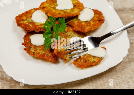 Frittelle di patate con panna acida e prezzemolo Foto Stock