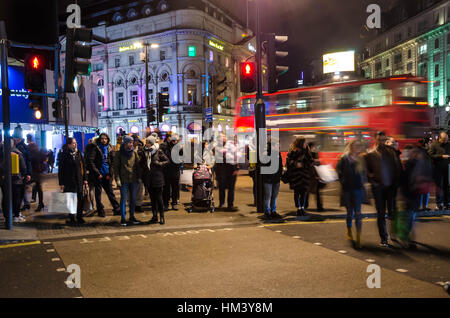 Persone attraversano Regent Street a un attraversamento pedonale a Piccadilly Circus a Londra. Foto Stock