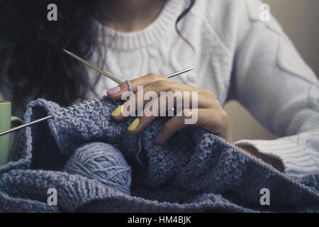 Al centro dell'immagine di una giovane ragazza in mano con bright manicure mantiene la maglia con raggi. La bambina indossa un maglione bianco. Foto d'epoca. Cl Foto Stock