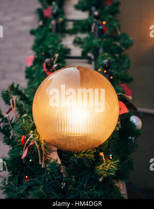 Round strada lampada incandescente tra le decorazioni di Natale Foto Stock