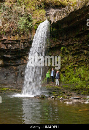 Walkers sostare dietro il Sgwd Gwladus cascata vicino Ystradfellte nel Brecons, Galles. Foto Stock