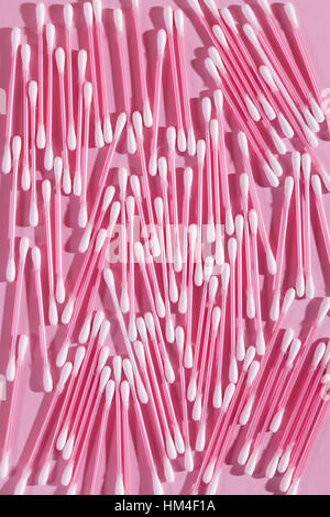 Molti dei tamponi di cotone su un sfondo rosa, vista dall'alto, inquadratura verticale Foto Stock