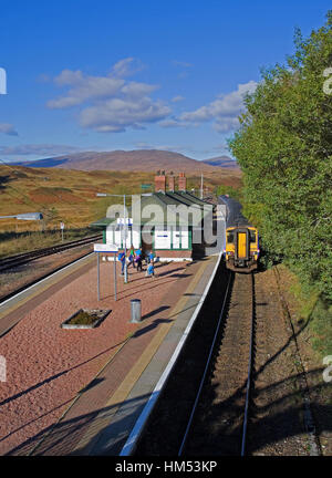 Un treno in direzione nord in attesa presso la piattaforma di Rannoch stazione ferroviaria, sul bordo di Rannoch Moor, in un assolato pomeriggio autunnale, Highlands scozzesi UK Foto Stock