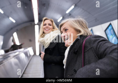 Due donne in piedi alla scala mobile nella metropolitana di Vienna Foto Stock