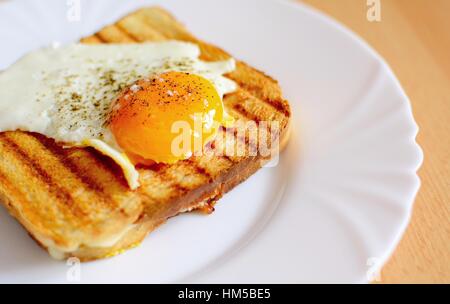 Prosciutto e formaggio toast con uovo fritto sulla parte superiore. Foto Stock