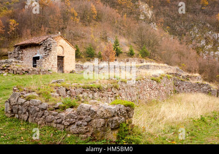 Vecchia casa di pietra nel bosco in montagna Foto Stock