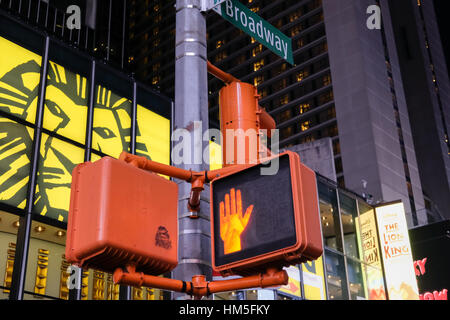 A piedi, non camminare a piedi i segnali di segno visibile in Broadway, New York City durante il tramonto con un teatro in background. Foto Stock