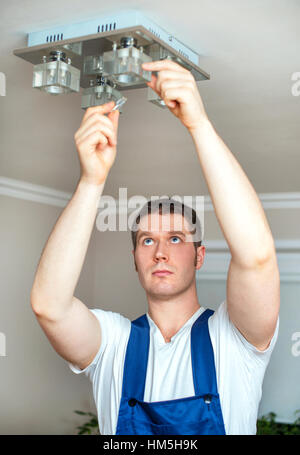 Elettricista maschio modifica della lampadina. Foto Stock